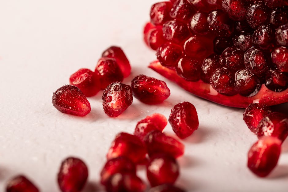 Grenade et peau : les bienfaits anti-âge de ce superfruit pour votre épiderme glass of pomegranate juice next to fresh pomegranate seeds healthy lifestyle