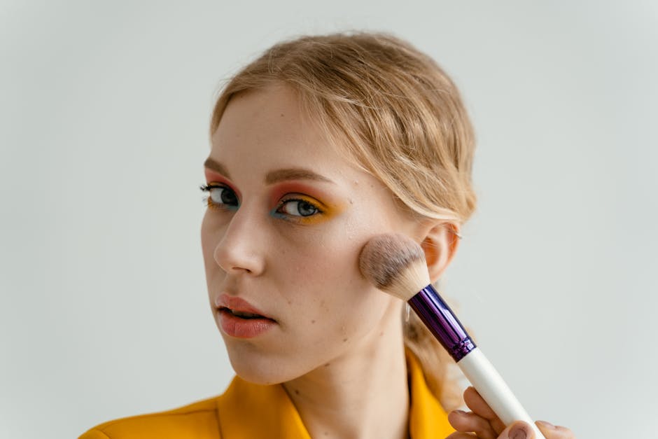 Teint nude réussi : les gestes essentiels pour une peau lumineuse sans effet masque woman applying blush bronzer natural light warm glow cheekbones