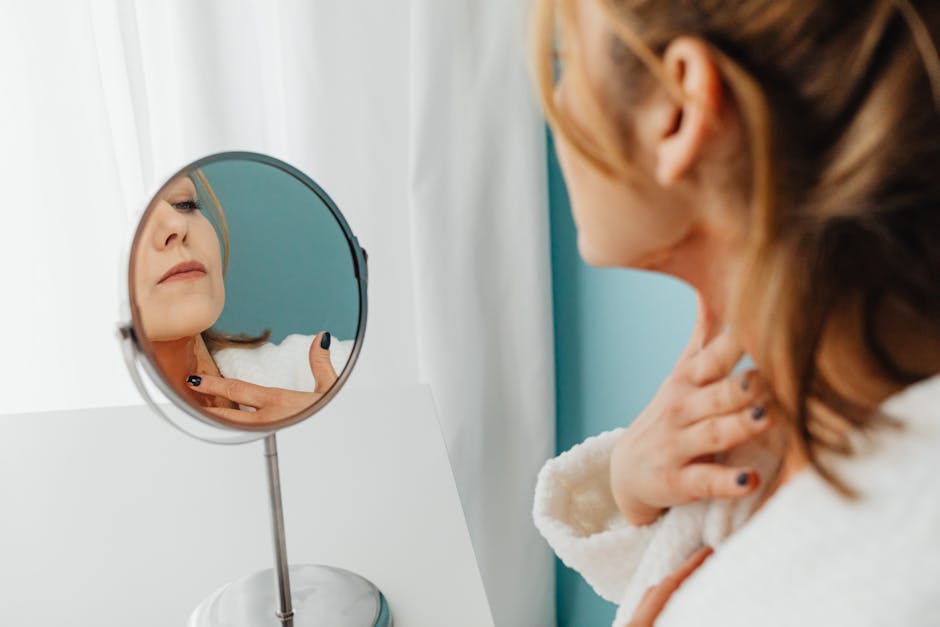 Cou et peau mature : le rituel complet pour raffermir et prendre soin de cette zone oubliée woman applying facial oil to neck evening skincare routine