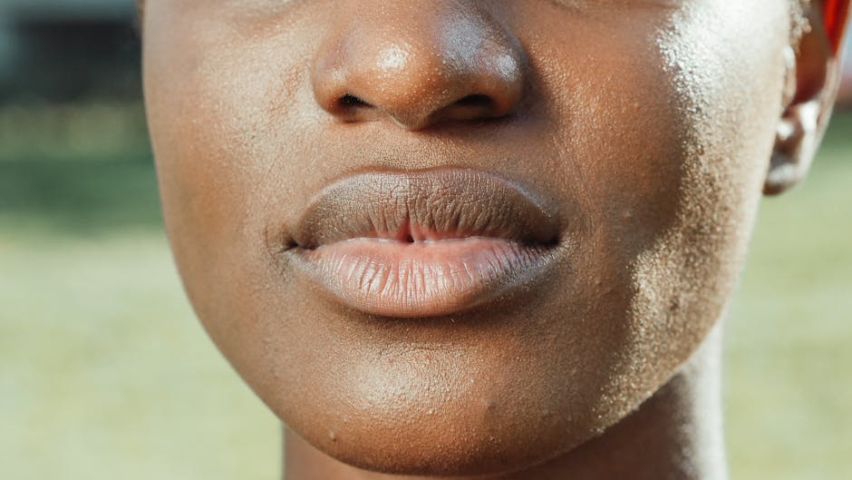 Peau noire et acné : comprendre, prévenir et atténuer les imperfections durablement close up portrait of a woman with dark skin and glowing natural complexion