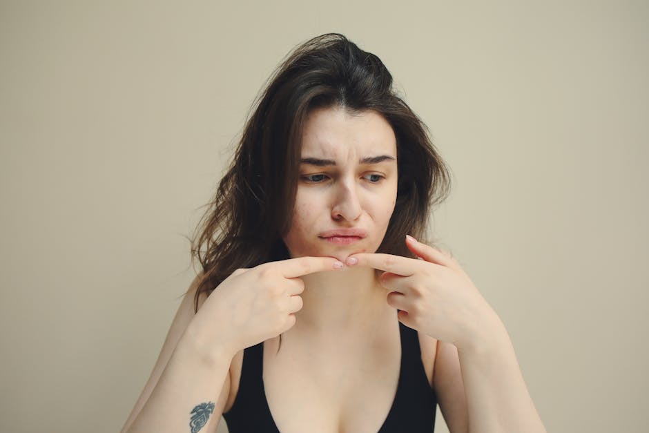 Se coucher sans se démaquiller : ce qui arrive vraiment à votre peau woman with acne prone skin looking at mirror concerned