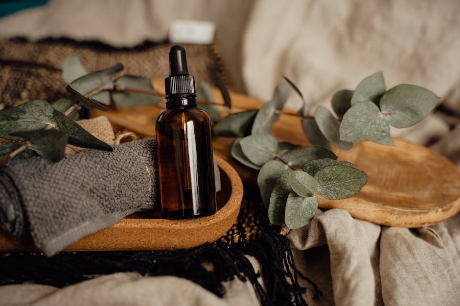 glass bottles plant-based oils wooden surface green leaves
