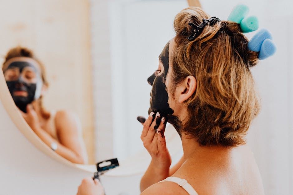 Le masque magnétique : comment fonctionne ce soin visage innovant ? woman applying black magnetic face mask with spatula skincare routine