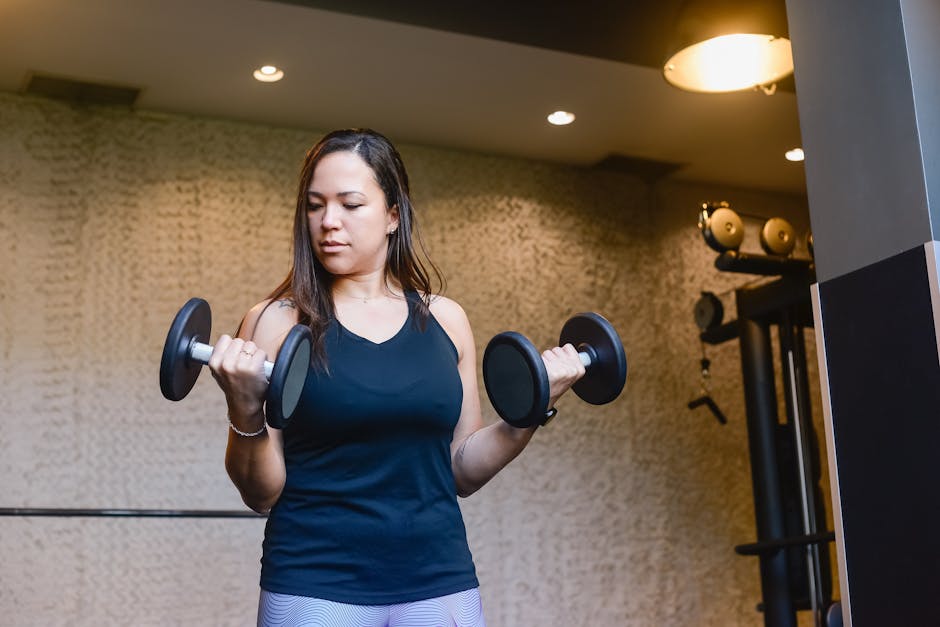 Musculation au féminin : bienfaits pour le corps, la peau et le bien-être woman doing strength training in gym bright natural light