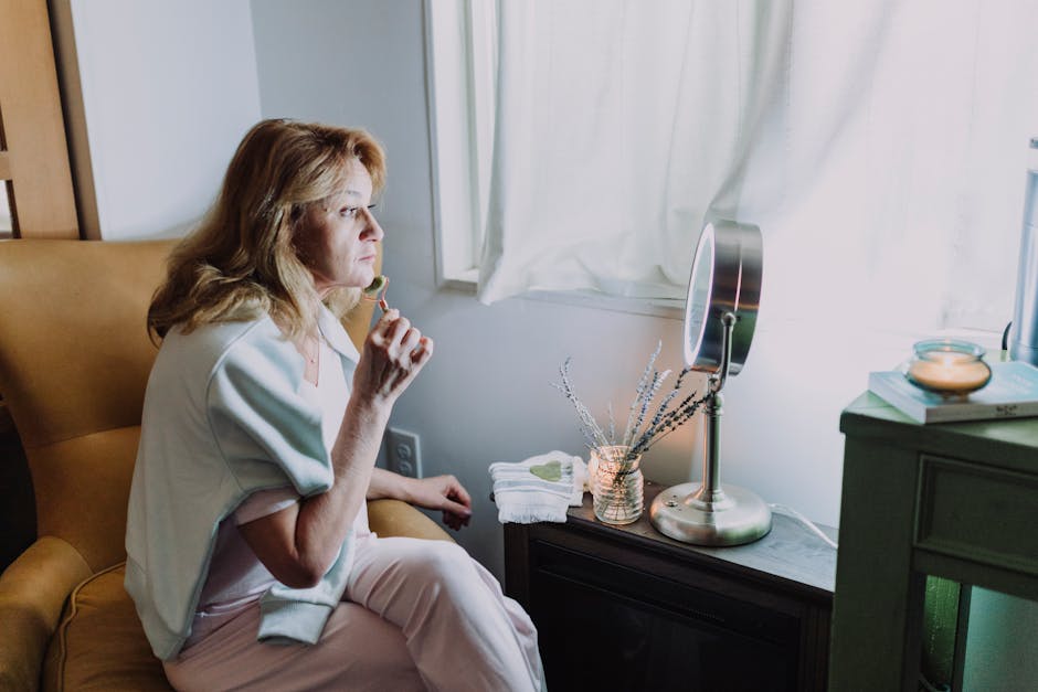 Visage repulpé : comment les soins anti-âge aident à retrouver fermeté et volume mature woman touching face mirror natural light skincare